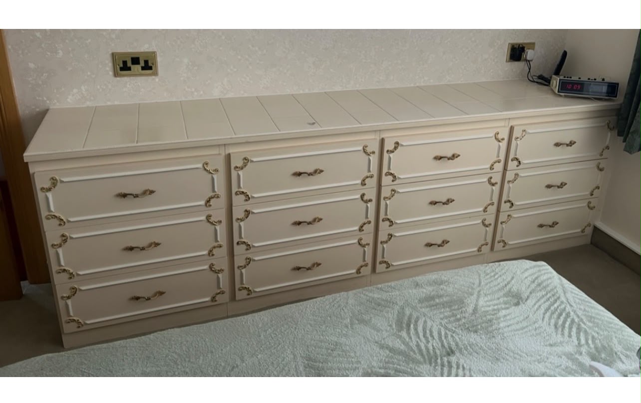 A long run of fitted bedroom drawer units before removal