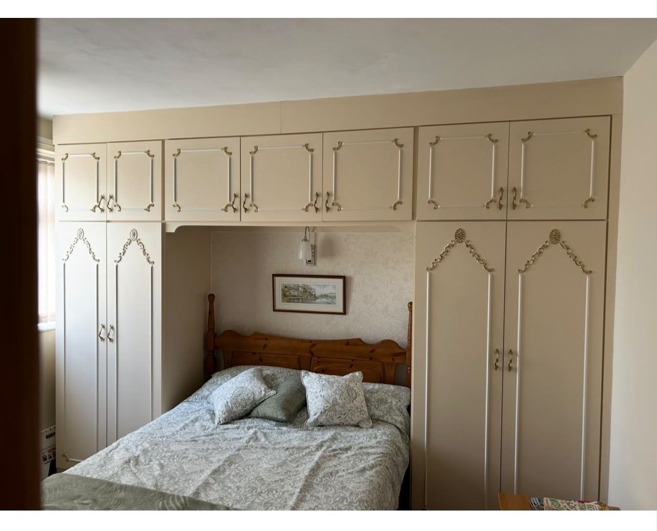 Fitted overbed wardrobes around a double bed before removal